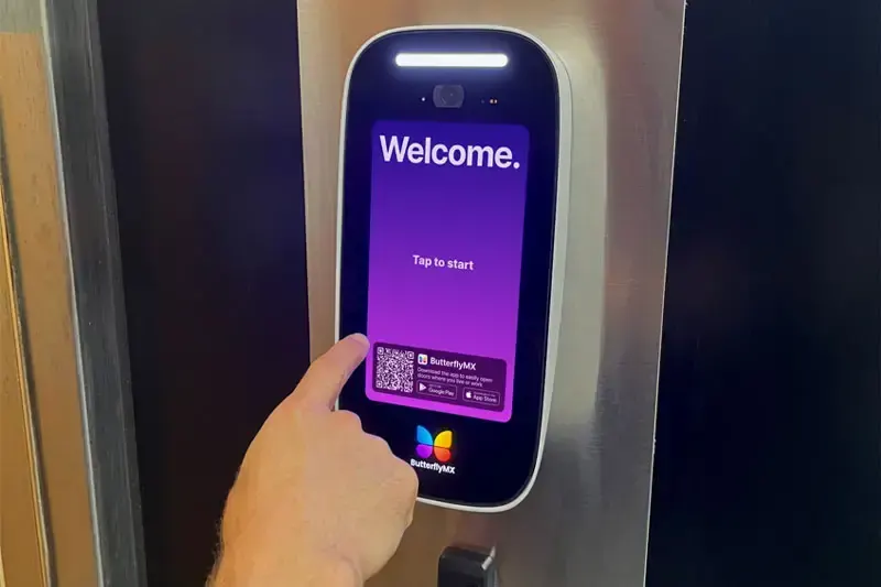 A visitor tapping the ButterflyMX welcome screen